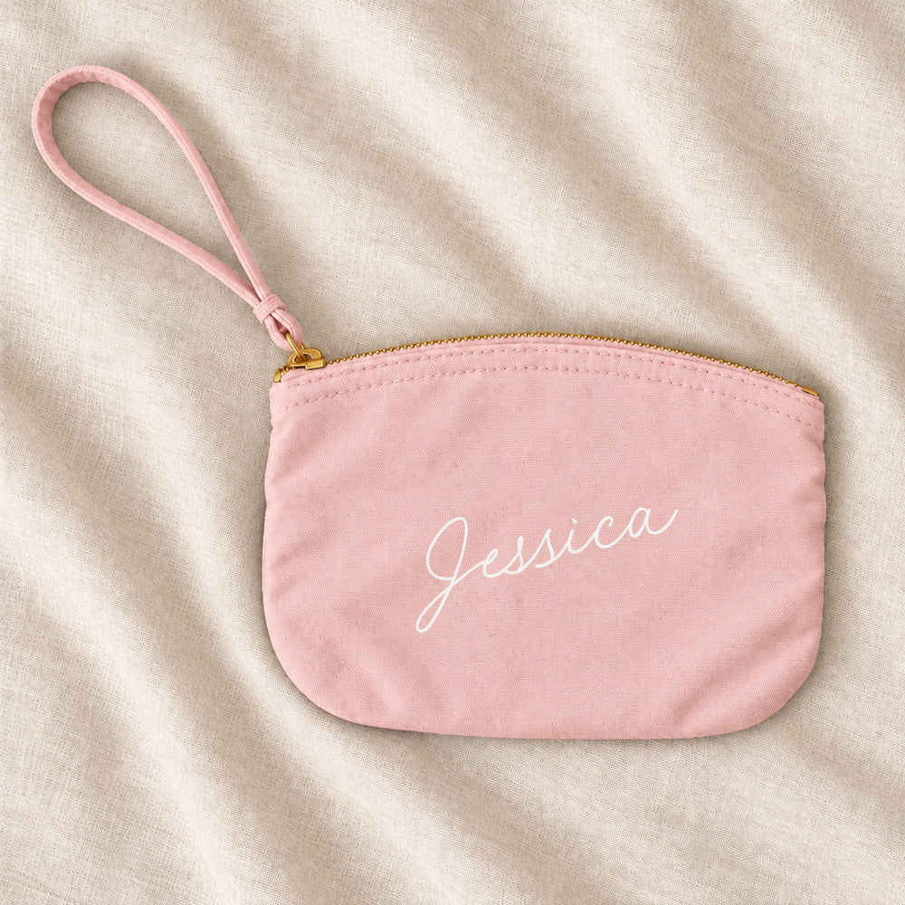 Blush pink personalised bridesmaid wristlet pouch with the name Jessica, on ivory linen