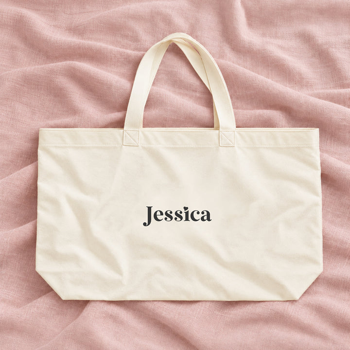 Natural cream canvas personalised bridesmaid XL tote bag with the name Jessica, on blush linen