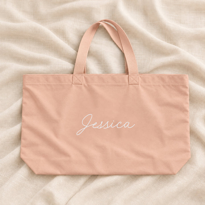 Pale peach personalised bridesmaid XL tote bag with the name Jessica in script, on ivory linen