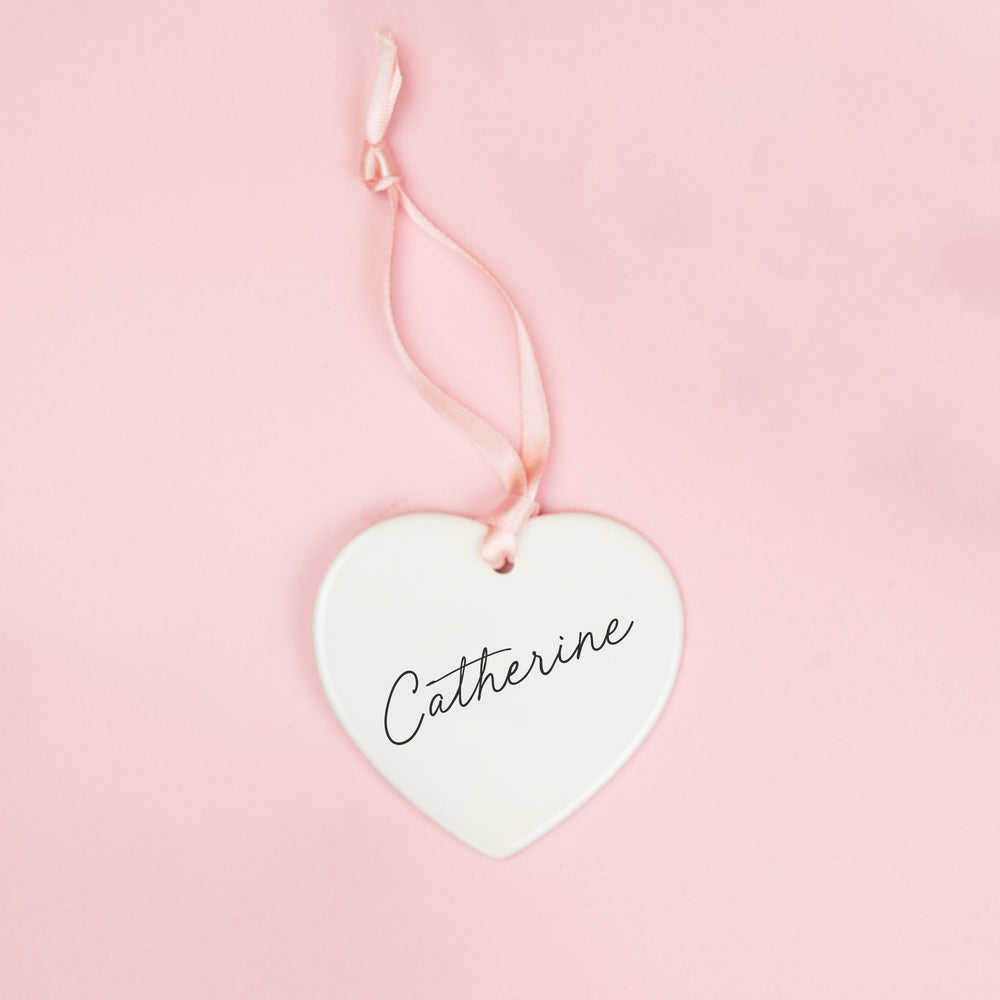White ceramic heart keepsake personalised with a bridesmaid’s name in black script lettering