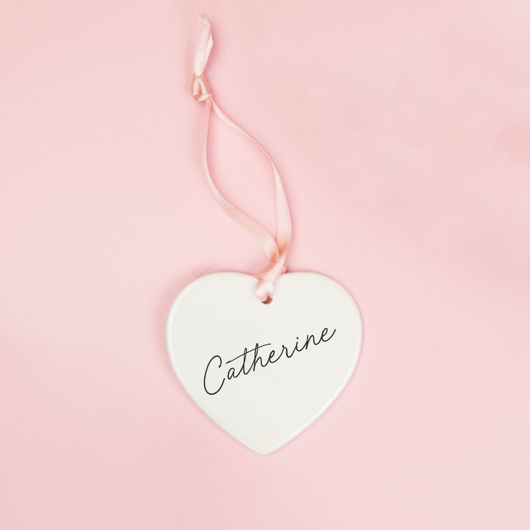 White ceramic heart keepsake personalised with a bridesmaid’s name in black script lettering