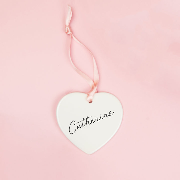 White ceramic heart keepsake personalised with a bridesmaid’s name in black script lettering