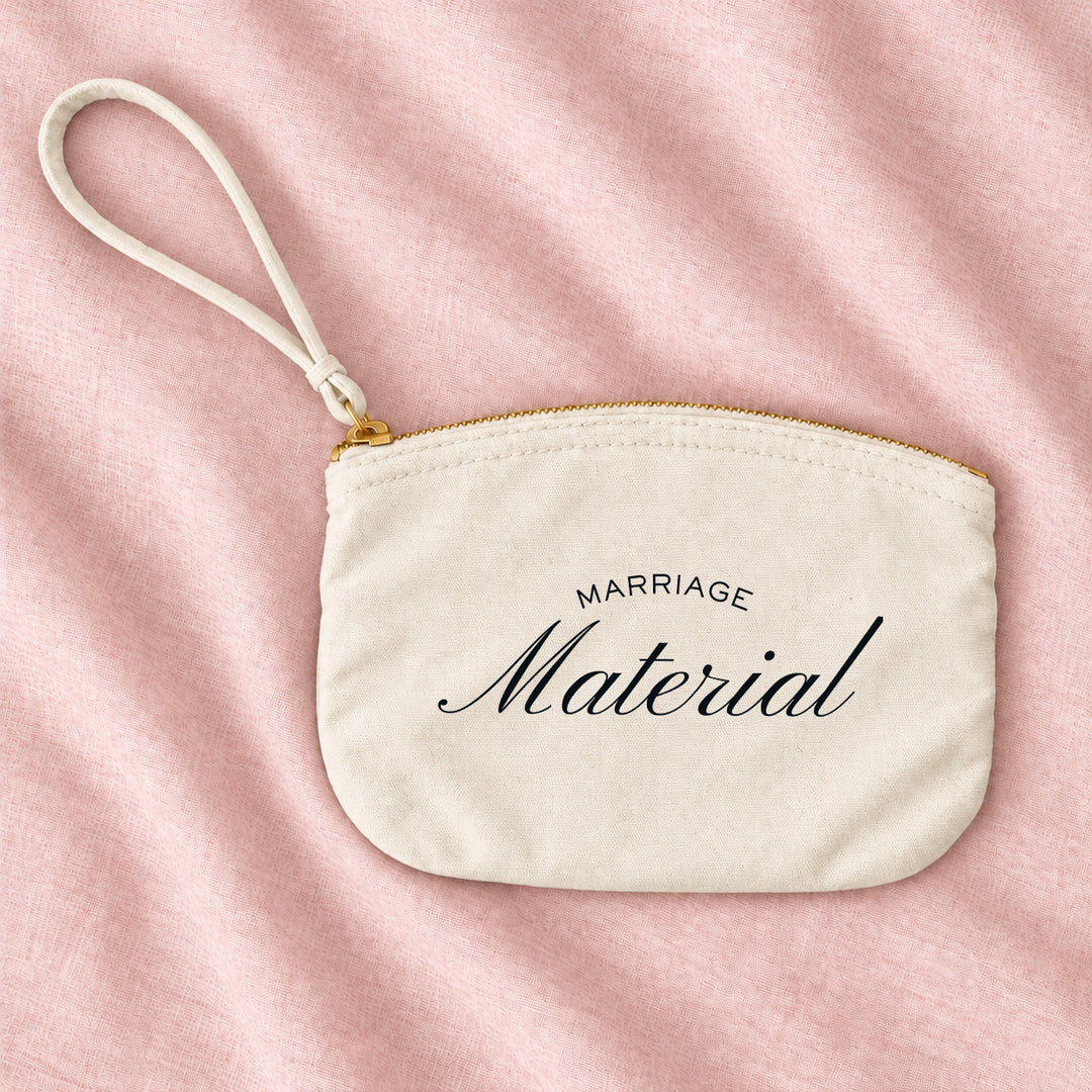 Cream canvas Marriage Material wristlet pouch on blush linen